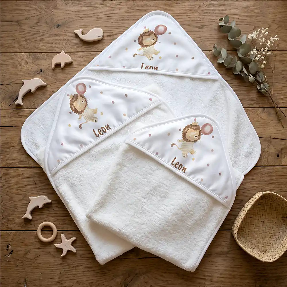 Personalisiertes Kapuzenhandtuch Baby Löwe Geburtstag – Flatlay mit Eukalyptus und Beißring