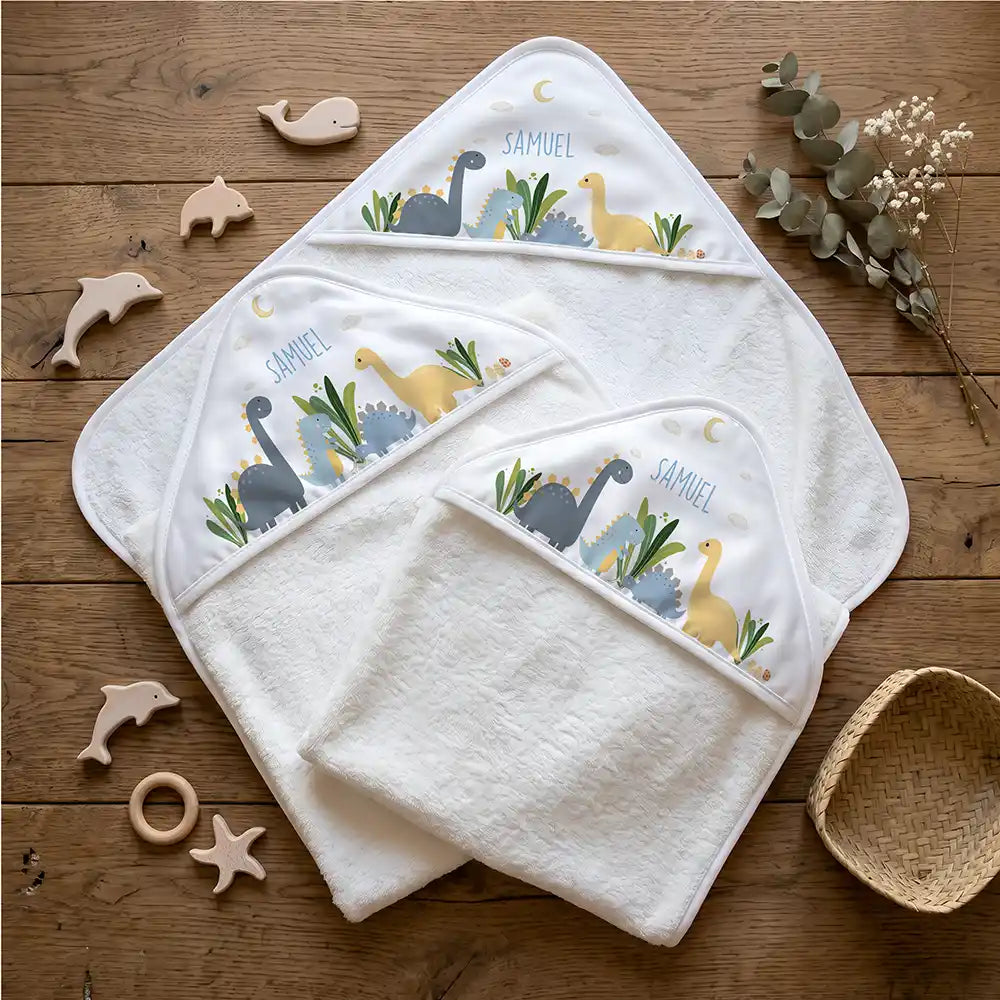 Personalisiertes Kapuzenhandtuch Baby Dinosaurier Mond – Flatlay mit Eukalyptus und Beißring