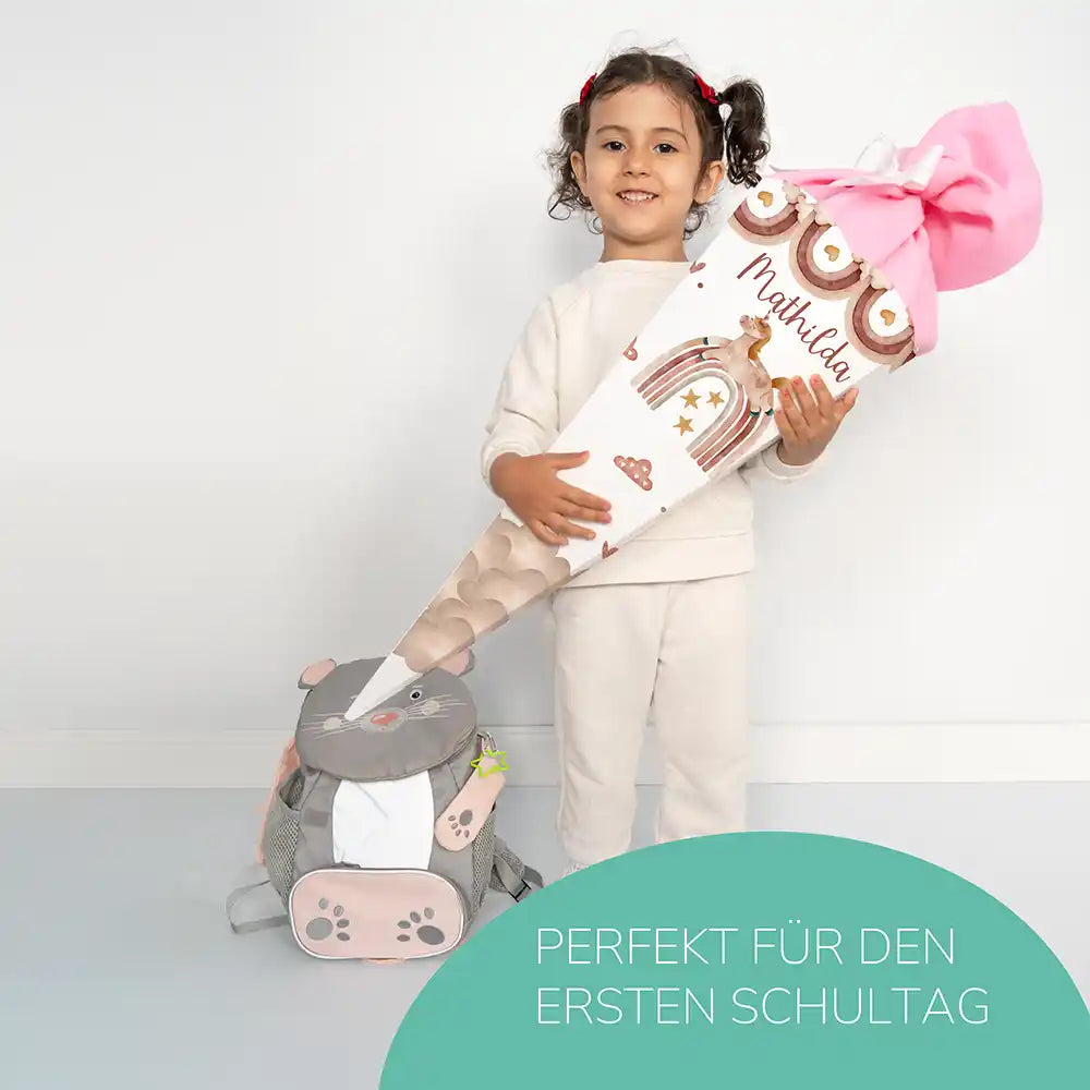 Kind hält personalisierte Einhorn Boho Regenbogen Schultüte mit Namen Mathilda für den ersten Schultag - Einschulung Geschenk.