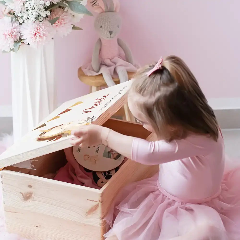 Mädchen entdeckt personalisierte Einhorn-Erinnerungsbox zur Geburt - magisches Babygeschenk in Rosa mit Wimpelkette